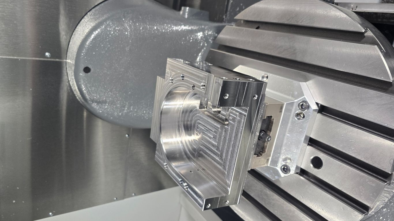 A metal component is being machined on a complex industrial machine.